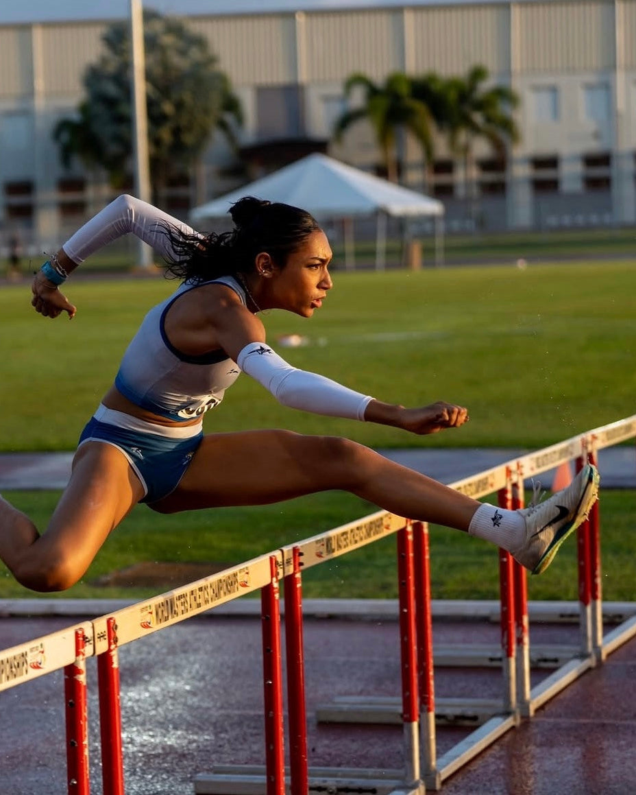 Athlete leaping over a hurdle on a track