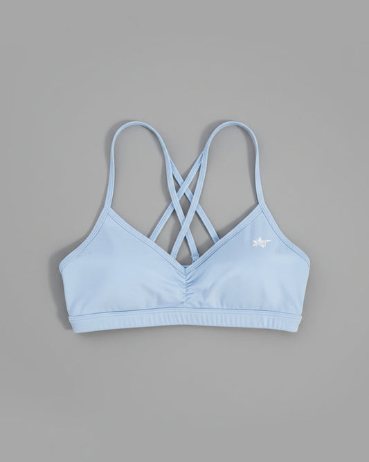 Light blue bralette on a brown textured surface